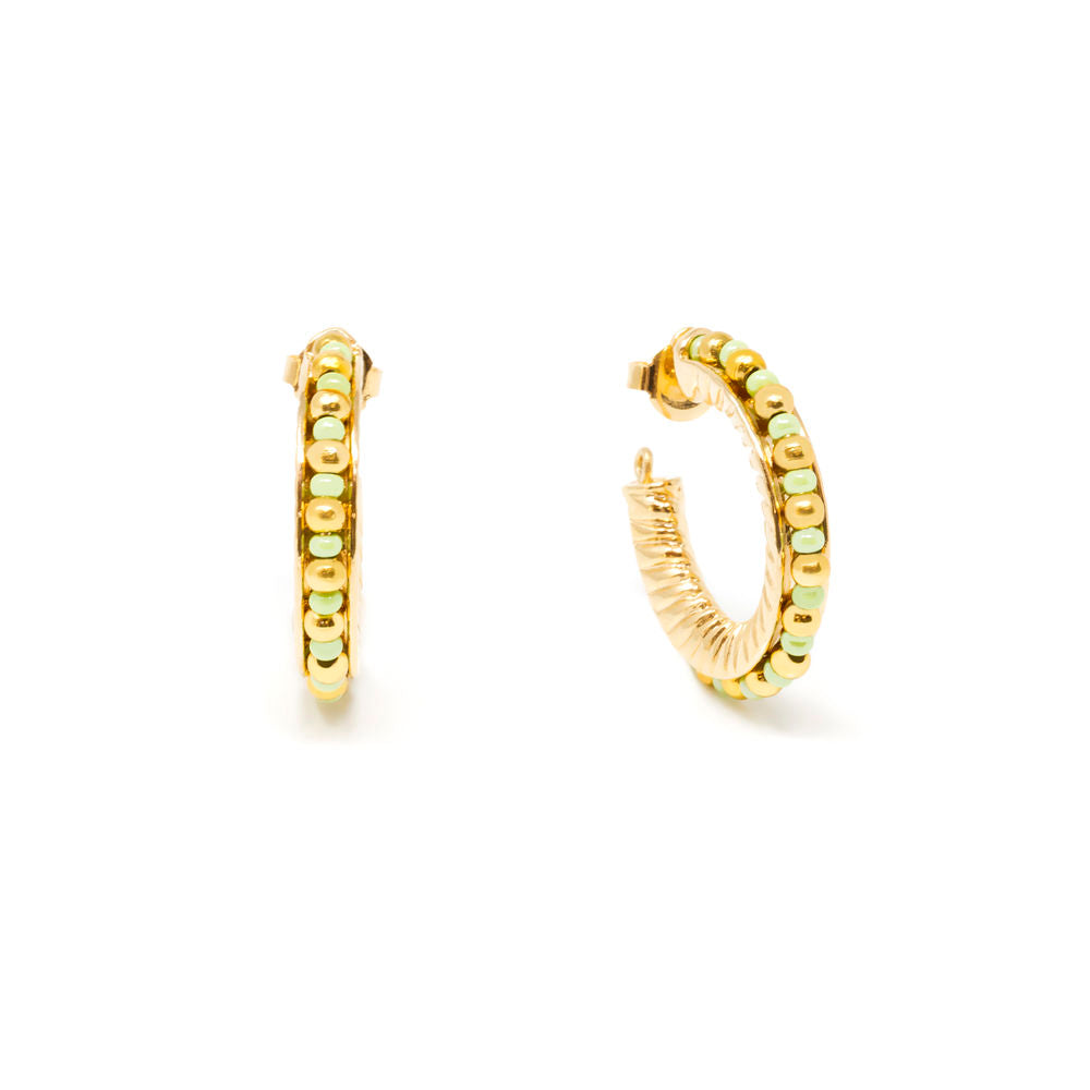 Polished gold 3 cm hoop earrings with green and gold beads, close-up on ear-ready posts