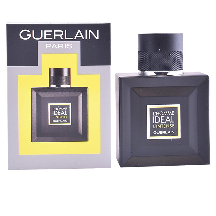 Clear square glass bottle with light amber liquid, black textured cap and simple front label, Guerlain.